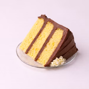Yellow cake with chocolate frosting and white chocolate shavings on top.